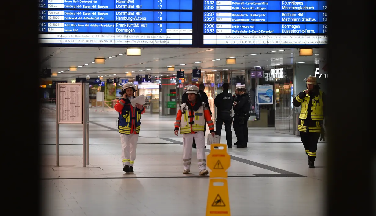 Petugas darurat mengamankan lokasi setelah seorang pria bersenjata kapak mengamuk di sebuah stasiun kereta api di Dusseldorf, Jerman, Kamis (9/3). Polisi belum merilis identitas pelaku dan motif serangan dalam penyelidikan. (Patrik STOLLARZ/AFP)