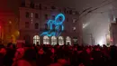 Orang-orang berjalan di sebelah stasiun kereta api Lyon-Saint-Paul yang diterangi cahaya lampu selama Festival of Lights (Fete des Lumieres) di kota Lyon, Prancis, Kamis (5/12/2019). Festival Cahaya ini merupakan salah satu kegiatan yang paling terkenal di Lyon. (ROMAIN LAFABREGUE / AFP)