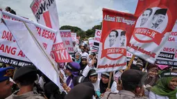 Massa membawa sejumlah atribut saat aksi unjuk rasa di depan Istana Merdeka, Jakarta, Selasa (7/4/2015). Mereka menagih janji Presiden Jokowi mencabut moratorium terkait larangan pengiriman TKI ke Timur Tengah. (Liputan6.com/Faizal Fanani)