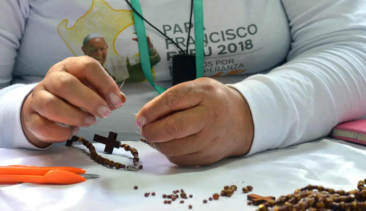 Seorang narapidana di penjara Wanita Virgen de Fatima membuat rosario kayu di Lima, Peru (12/1). Penjara Virgen de Fatima hanyalah satu dari 12 lembaga pemasyarakatan yang membuat rosario untuk kunjungan Paus Fransiskus. (AFP Photo/Cris Bouroncle)