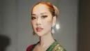 Bunga Citra Lestari tampil elegan dalam balutan kebaya kutubaru brokat berwarna hijau botol yang dipadukan dengan selendang merah dan bros emas. [@itsmebcl]