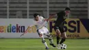 Bek Bali United, Ricky Fajrin, saat berebut bola dengan bek Timnas Indonesia pada laga uji coba di Stadion Madya, Minggu (7/3/2021). (Bola.com/ Ikhwan Yanuar Harun)