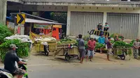 Pedagang Pasar Sayur Kedungrejo Malang tak bisa mengirim sayur ke Surabaya dengan lancar sejak PSBB. Di Kota Batu, aktivitas pengiriman pasar sayur antar kota dikhawatirkan jadi transmisi lokal Corona Covid-19 (Liputan6.com/Zainul Arifin)