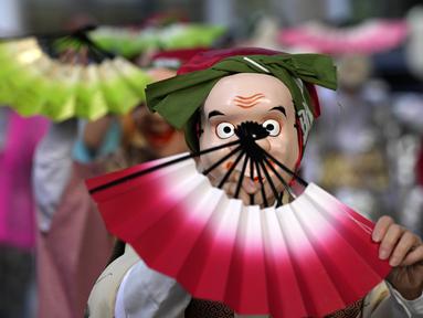 Seniman yang mengenakan topeng badut tradisional Jepang tampil selama Festival Konpira di kuil Kotohiragu di distrik bisnis Toranomon, Tokyo, Selasa (10/1/2023). Festival Konpira pertama di tahun 2023 ini dimeriahkan dengan penampilan para seniman yang mengenakan topeng tradisional Jepang. (AP Photo/Eugene Hoshiko)