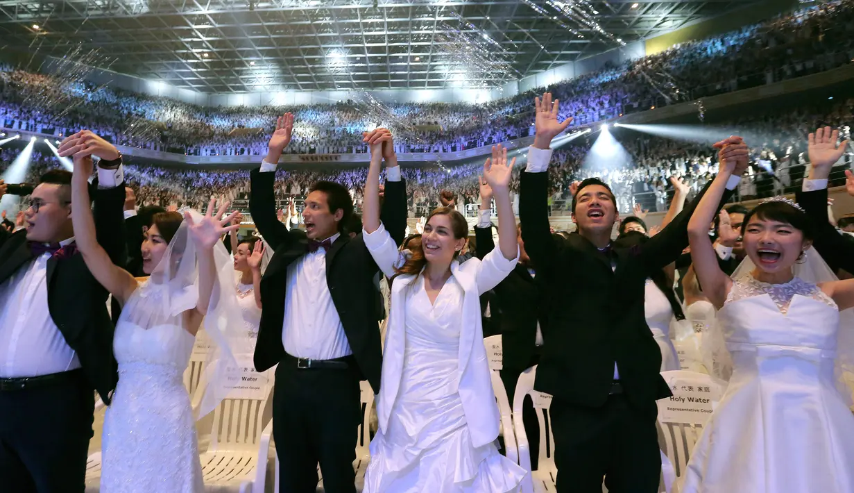 Sejumlah pasangan bergembira saat mengikuti pernikahan massal di Pusat Perdamaian Cheong Shim di Gapyeong, Korea Selatan, (7/9). Sebanyak 4.000 pasangan Korea Selatan dan asing ikut serta dalam acara ini. (AP Photo / Ahn Young-joon)