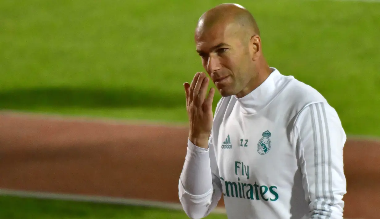 Pelatih Real Madrid, Zinedine Zidane, mengamati anak asuhnya saat latihan di Stadion NY University Abu Dhabi, UAE, Senin (11/12/2017). Los Blancos bersiap jelang semifinal FIFA Club World Cup. (AFP/Giuseppe Cacace)