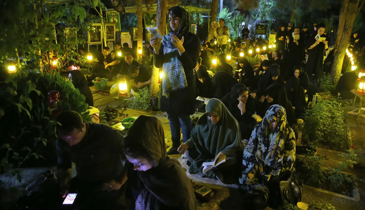 Umat Syiah Iran berkumpul sambil membaca Al Quran saat malam Ramadan di Teheran, Iran (16/6). Malam tersebut bertepatan dengan tanggal 21 Ramadan. Mereka berdoa mengharapkan mendapat malam Lailatul Qadar. (AP Photo/Vahid Salemi)
