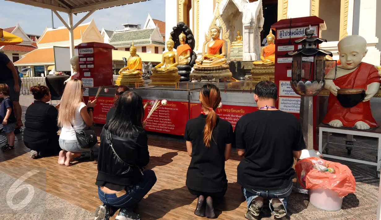 Pengunjung berdoa di kawasan kuil Golden Budha di kota Bangkok, Thailand, Sabtu (17/12). Salah satu biksu yang ada di kuil tersebut memprediksi hasil laga final kedua Piala AFF 2016 antara Thailand melawan Indonesia. (Liputan6.com/Helmi Fithriansyah)