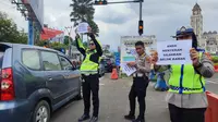 Petugas kepolisian mengimbau pengendara untuk mengurungkan perjalanannya ke Puncak, Bogor mengingat lalu lintas di kawasan itu sangat padat, Senin (24/4/2023). (Liputan6.com/ Achmad Sudarno)