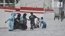 Warga membantu pengguna kereta menerobos banjir di Jalan Abdullah Syafei, Tebet, Jakarta, Kamis (18/2/2021). Hujan deras yang mengguyur sejak pagi menyebabkan aliran Kali Tebet meluap hingga merendam Jalan Abdullah Syafei dengan ketinggian mencapai sepaha orang dewasa. (merdeka.com/Iqbal S Nugroho)