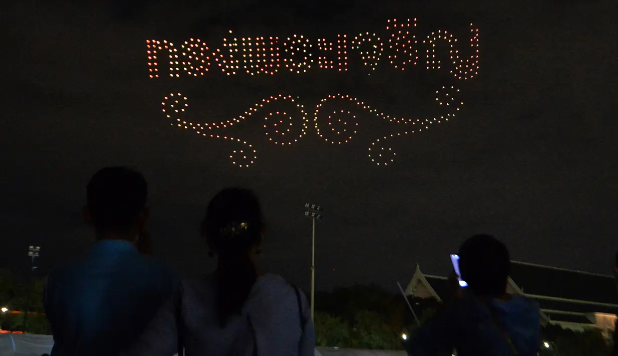 Orang-orang menyaksikan pertunjukan drone pada sebuah acara untuk merayakan ulang tahun ke-88 Ibu Suri Thailand, Ratu Sirikit, di dekat Grand Palace di Bangkok, Thailand, pada 12 Agustus 2020. (Xinhua/Rachen Sageamsak)