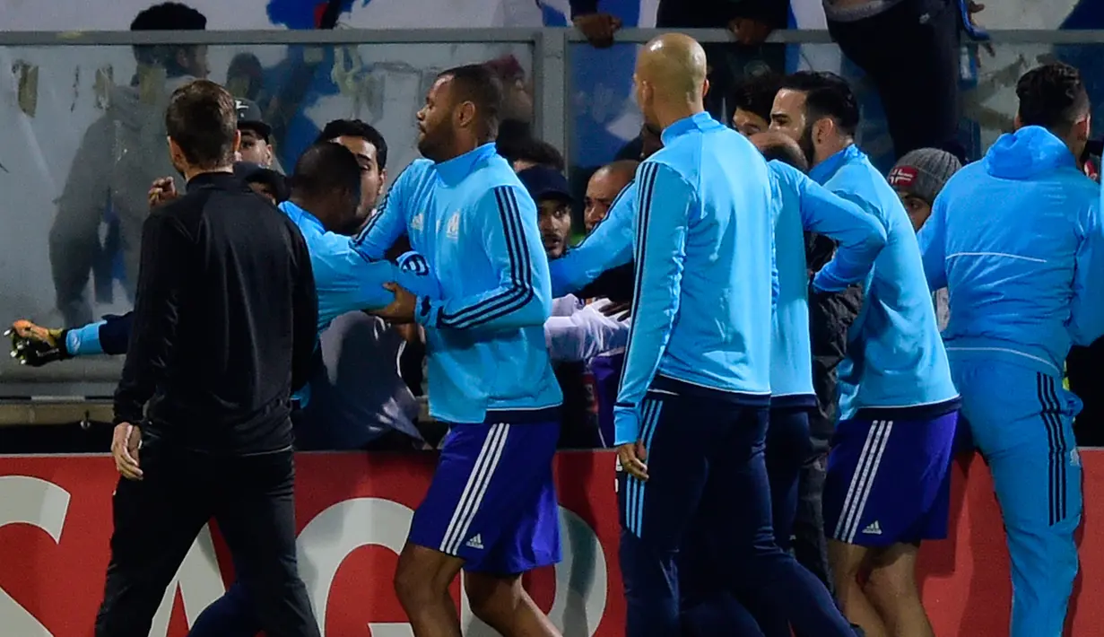 Bek Olympique Marseille, Patrice Evra menendang suporter menjelang partai Liga Europa lawan Vitoria Guimaraes di Estadio D. Afonso Henriques, Jumat (3/11). Evra menendang kepala suporter yang berada di balik papan iklan pinggir lapangan (MIGUEL RIOPA/AFP)