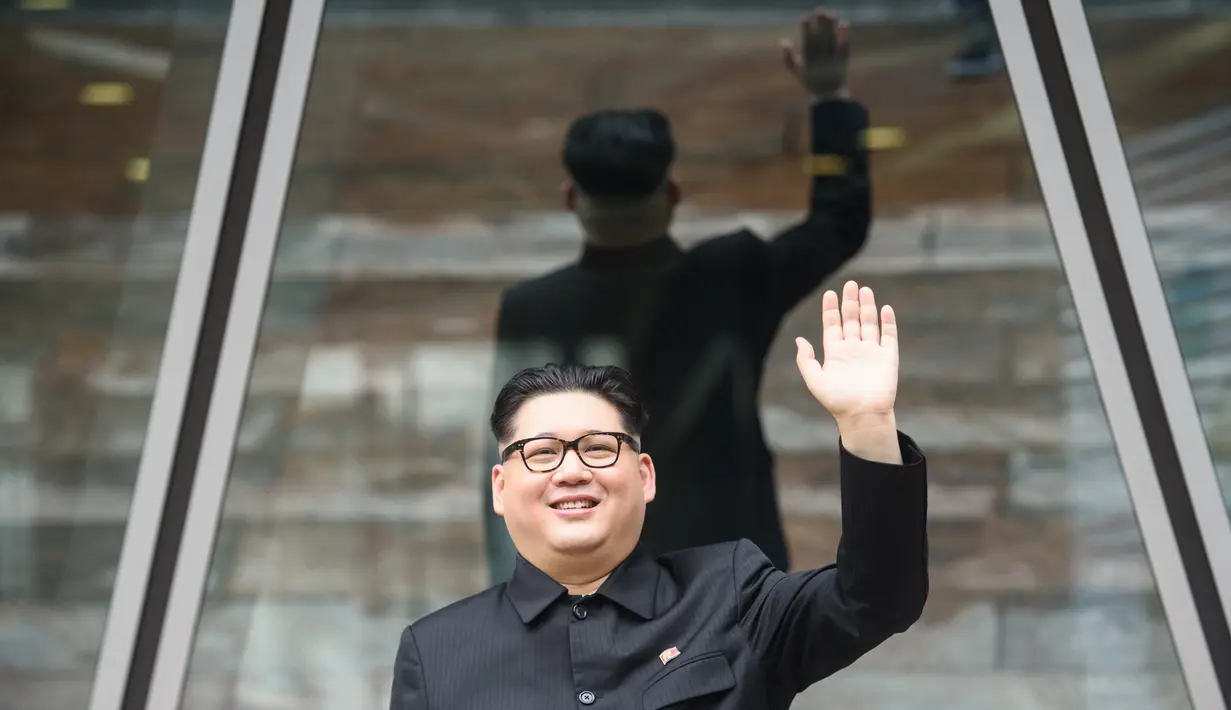 Howard X yang mirip Kim Jong-un melambai ke luar gedung di Hong Kong (7/6). Ketika dunia menunggu pertemuan bersejarah antara Presiden AS Donald Trump dan Kim Jong Un, Howard X akan tampil di Singapura. (AFP Photo/Anthony Wallace)