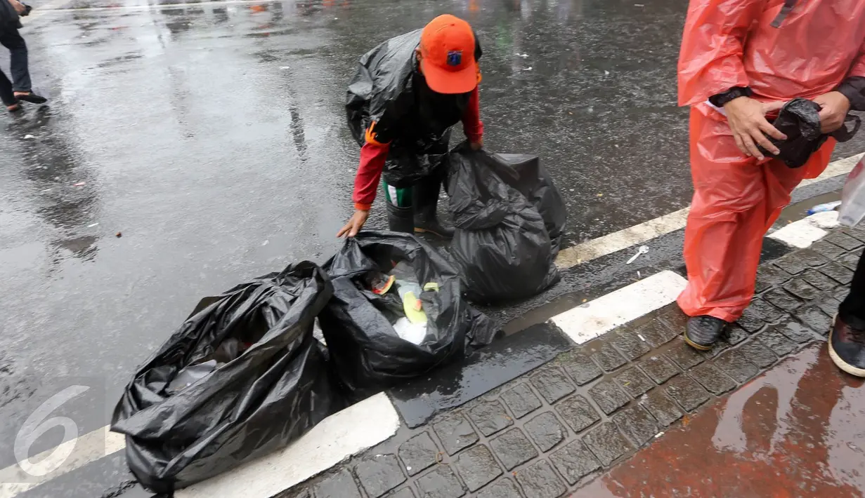 Seorang petugas kebersihan DKI Jakarta membersihkan sampah usai aksi damai 2 Desember di kawasan Jalan MH Thamrin, Jakarta, Jumat (2/12). Aksi damai 2 Desember digelar sebagai lanjutan dari aksi 4 November 2016. (Liputan6.com/Ferbian Pradolo)