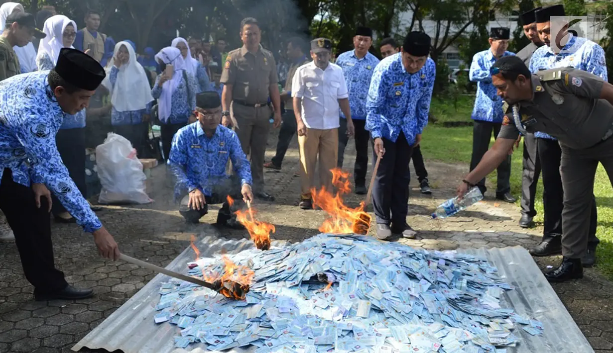 Petugas membakar KTP Elektronik yang rusak untuk dimusnahkan di halaman Kantor Bupati Bone Bolango (Bonebol), Gorontalo, Selasa (18/12). Sebanyak 28.130 E-KTP rusak dimusnahkan untuk menghindari adanya penyalahgunaan. (Liputan6.com/Arfandi Ibrahim)