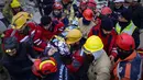 Tim penyelamat mengevakuasi seorang gadis Suriah berusia 12 tahun, Cudi, dari puing-puing bangunan yang hancur di Hatay, Turki, setelah gempa berkekuatan 7,8 melanda tenggara negara itu, Minggu (12/2/2023). Hatay, yang berbatasan dengan barat laut Suriah adalah provinsi terparah di Turki yang terkena gempa dahsyat.  (Photo by Yasin AKGUL / AFP)