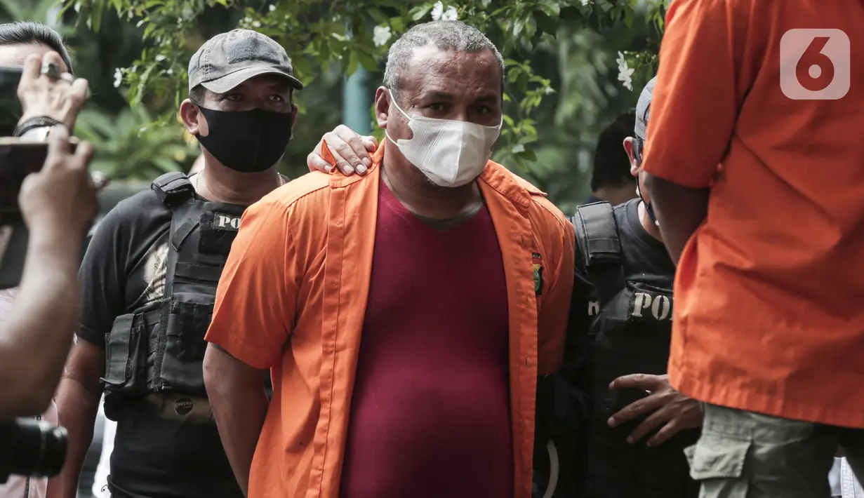 John Kei digiring saat rilis kasus premanisme oleh kelompoknya di Polda Metro Jaya, Jakarta, Senin (22/6/2020). Dirkrimum Polda Metro Jaya menangkap 30 tersangka dan sejumlah barang bukti senjata tajam. (Liputan6.com/Johan Tallo)