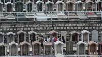 Orang-orang mengunjungi Pemakaman China Cape Collinson untuk memberi penghormatan kepada orang tercinta yang telah meninggal di dekat Chai Wan, Hong Kong, 5 April 2021. Kegiatan ini untuk menandai Festival Ching Ming yang juga dikenal sebagai pembersihan makam. (Peter PARKS/AFP)