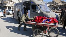 Warga mendorong gerobak yang mengangkut seorang wanita untuk dievakuasi dari wilayah yang dikuasai pemberontak di Aleppo, Suriah, Kamis (15/12). Bus dan ambulans digunakan untuk mengevakuasi ribuan warga dari wilayah tersebut. (REUTERS/Abdalrhman Ismail)