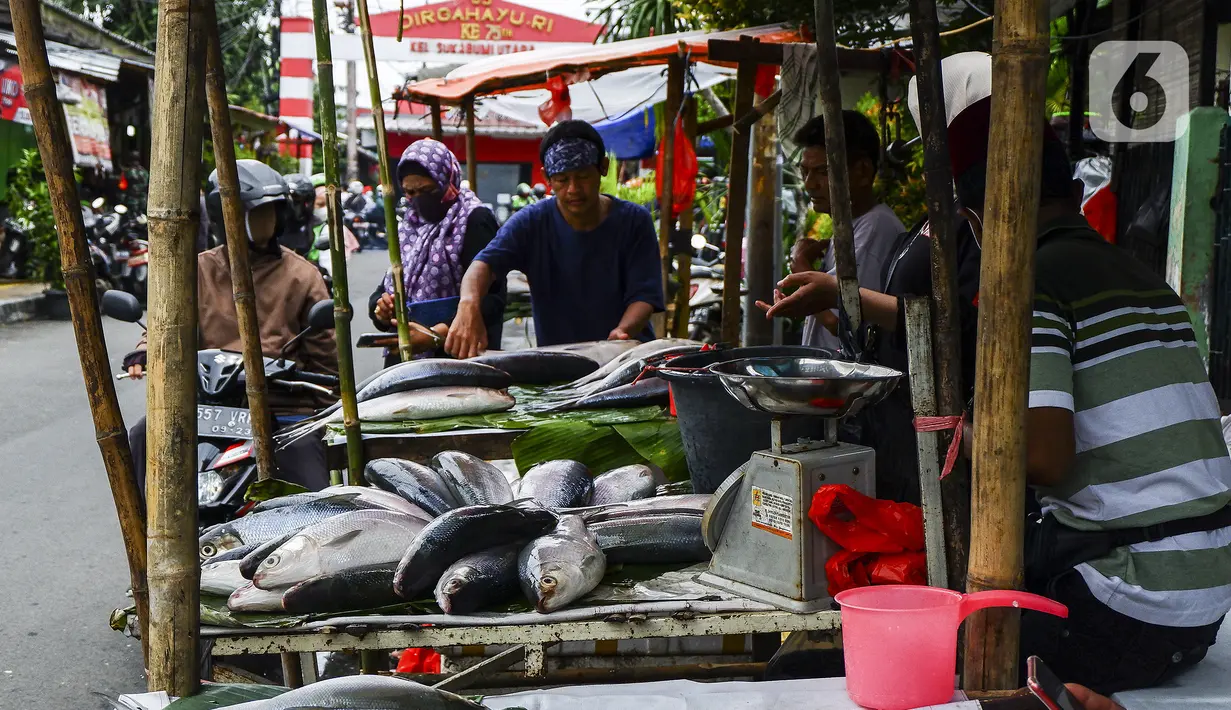 Pedagang ikan bandeng melayani pembeli di kawasan Rawa Belong, Jakarta Barat, Rabu (10/2/2021). Para pedagang ikan bandeng berdagang di pinggir jalan dan menjajakan kapada setiap pengendara yang melintas. (Liputan6.com/Johan Tallo)