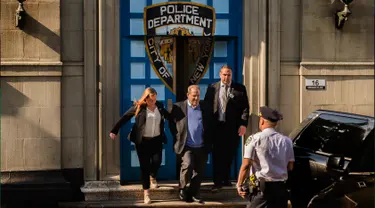 Produser Hollywood Harvey Weinstein dengan kawalan meninggalkan kantor polisi New York City setelah menyerahkan diri di New York, Jumat (25/5). Weinstein akhirnya menyerahkan diri terkait kasus pelecehan seksual yang menimpa dirinya. (AP/Andres Kudacki)