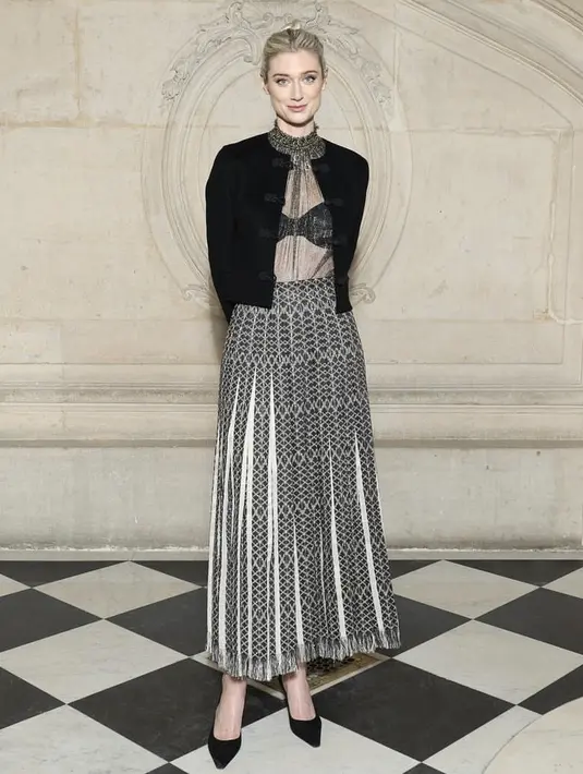 Elizabeth akrtis yang berperan sebagai Putri Diana dalam serial Netflix The Crown, memamerkan branya dengan atasan perak tipis yang dipasangkan dengan rok panjang berlipit dan jaket hitam berpotongan rapi. @dior