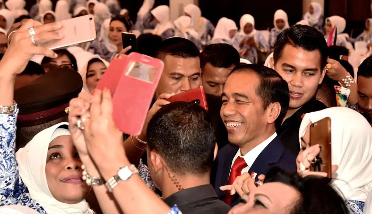 Presiden Joko Widodo foto bersama peserta saat membuka Rakernas IWAPI XXVIII di Padang, Senin (8/10). Jokowi yakin produk UMKM Indonesia tidak kalah bersaing dengan negara lain. (Liputan6.com/Pool/Biro Pers Setpres)