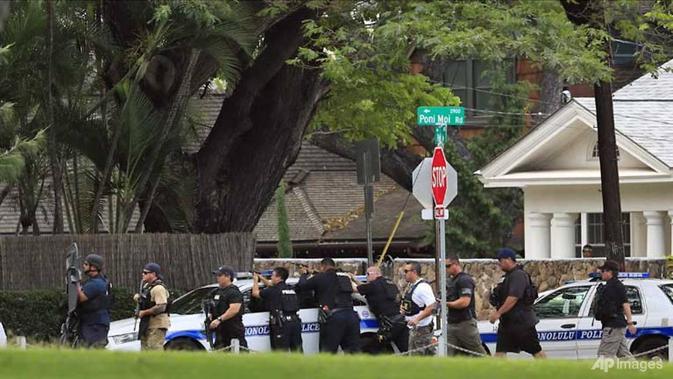Polisi Honolulu mengambil posisi dengan senjata mereka setelah insiden penembakan di kediaman di Hibiscus Road dekat Diamond Head. (Jamm Aquino/Honolulu Star-Advertiser/AP)