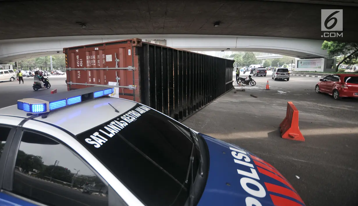 Mobil Polisi berada di dekat lokasi tergulingnya truk kontainer di kolong flyover Tomang, Jakarta, Kamis (28/6). Truk kontainer bernomor polisi BN 4706 BP tersebut terguling saat hendak berbelok arah ke Jalan Tomang Raya. (Merdeka.com/Iqbal S. Nugroho)