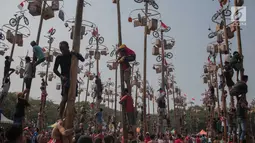 Warga mengikuti lomba Panjat Pinang Kolosal dalam rangka merayakan HUT ke-74 Kemerdekaan RI di Pantai Karnaval Ancol, Jakarta, Senin (17/8/2019). Sebanyak 174 batang pinang dengan beragam hadiah disediakan dalam lomba yang diikuti ratusan warga itu. (Liputan6.com/Faizal Fanani)