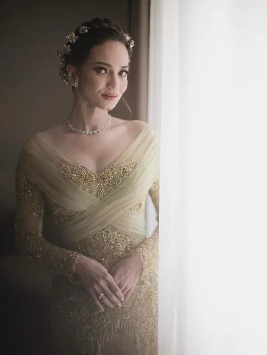 Enzy Storia terlihat sangat indah dan elegan dalam acara syukuran pernikahannya. Enzy menggunakan kebaya hijau lumut dengan songket Aceh. Perpaduan dengan nuansa Melayu dan sentuhan warna emas, membuat penampilannya tampak menawan dan berkesan mewah.  [@svarna_byikatindonesia].
