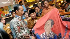Presiden terpilih Joko Widodo melihat batik bercorak dirinya, Pasaraya Blok M, Jakarta, Kamis (2/10/2014) (Liputan6.com/Herman Zakharia)