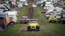 Mobil-mobil melewati kamp selama pertemuan dunia Citroen 2CV Friends di dekat Delemont, Swiss, 26 Juli 2023. (GABRIEL MONNET/AFP)