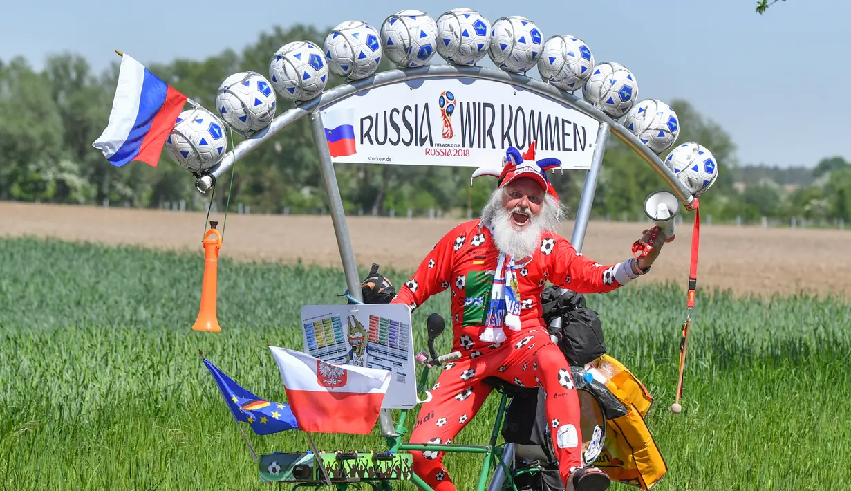 Aksi perancang sepeda asal Jerman, Dieter Senft atau Didi the Devil saat mengendarai sepeda unik buatannya di Briesen, Jerman Timur, Senin (7/5). Aksi itu dia lakukan untuk mempromosikan Piala Dunia 2018. (Patrick Pleu/dpa/AFP)