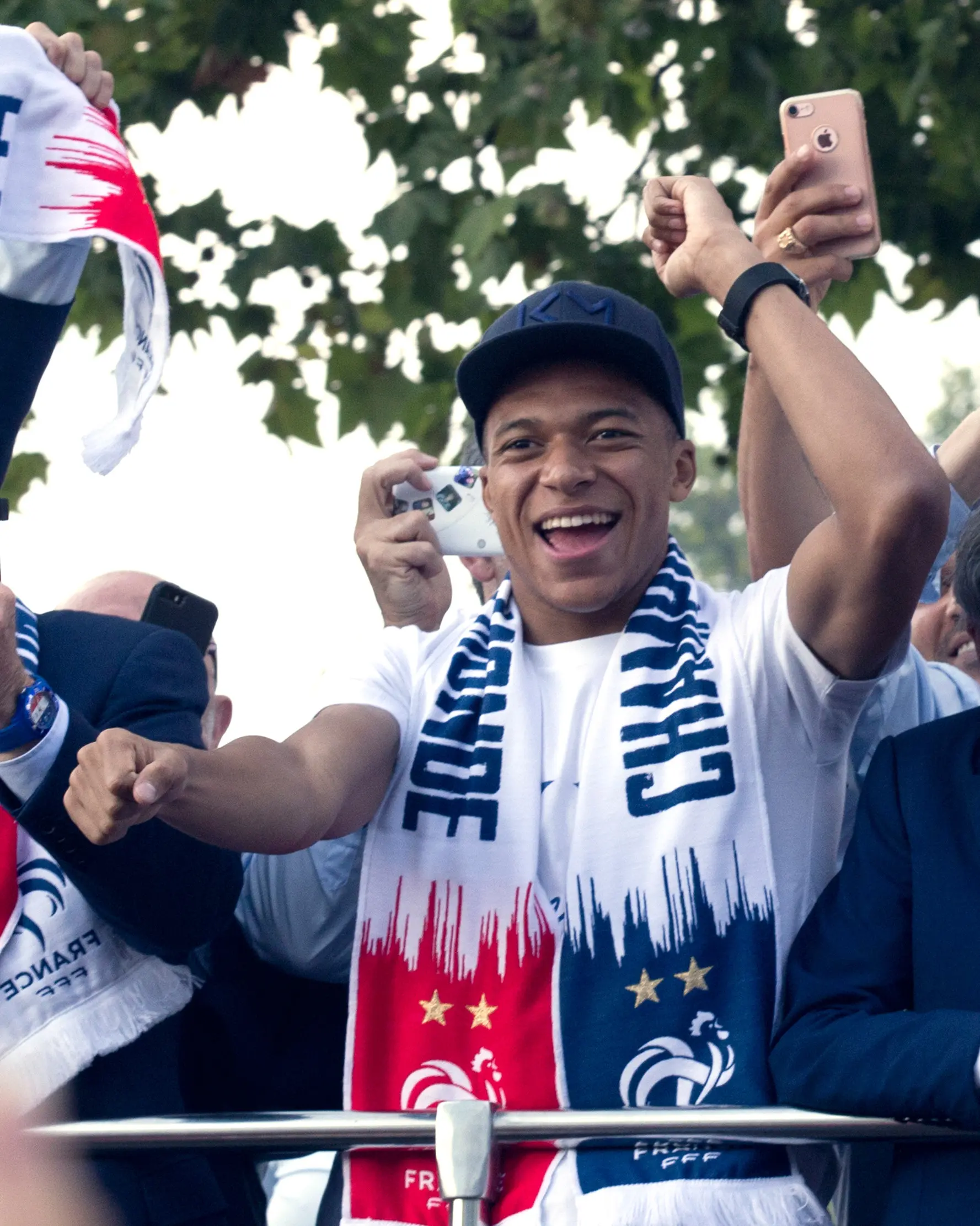 Striker timnas Prancis, Kylian Mbappe berada di atas bus beratap terbuka saat parade merayakan juara Piala Dunia 2018 di sepanjang Champs Elysees, Paris, Senin (16/7). Prancis meraih trofi Piala Dunia kedua usai mengalahkan Kroasia. (AP/Claude Paris)