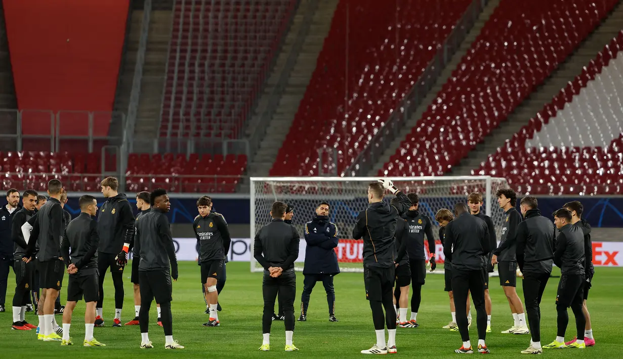 Para pemain Real Madrid melakukan pemanasan sebelum memulai sesi latihan di Red Bull Arena Stadium, Leipzig, Senin (12/2/2024) jelang menghadapi RB Leipzig pada leg pertama babak 16 besar Liga Champions 2023/2024. (AFP/Odd Andersen)