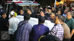 Kerabat mengangkat peti jenazah Mike Mohede dari ambulans setibanya di rumah duka kawasan Bintaro, Tangerang Selatan, Minggu (31/7). Mike Mohede dinyatakan meninggal sekitar pukul 18:02 WIB lantaran terkena serangan jantung. (Liputan6.com/Angga Yuniar)