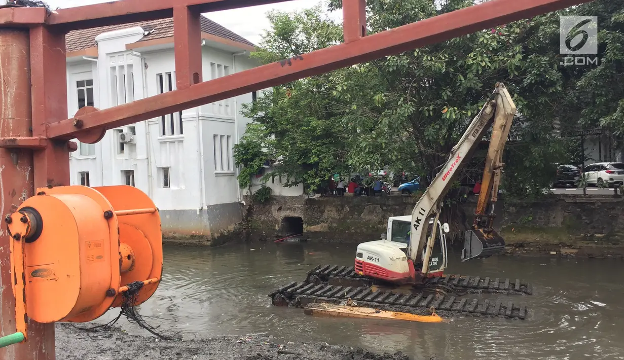 Alat berat digunakan untuk mengeruk lumpur dan sampah yang mengendap di anak Sungai Ciliwung, Jakarta, Jumat (26/1). Selain itu, pengerukan juga dilakukan mengantisipasi banjir seiring datangnya musim hujan. (Liputan6.com/Immanuel Antonius)