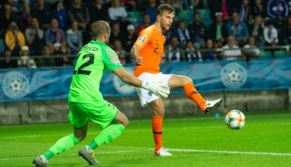 Bek Belanda, Joel Veltman, berusaha mengecoh kiper Estonia, Sergei Lepmets, pada laga Kualifikasi Piala Eropa 2020 di Talinn, Estonia, Senin (9/9). Estonia kalah 0-4 dari Belanda. (AFP/Raigo Pajula)