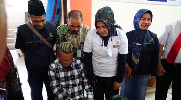 Disaksikasi Ketua Tim Penggerak Pemberdayaan Kesejahteraan Keluarga Kabupaten Garut Diah Kurniasari, salah satu penerima bantuan memasangkan kaki palsu bantuan. (Liputan6.com/Jayadi Supriadin)