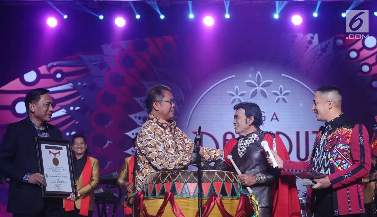 Menkominfo, Rudiantara (kedua kiri) menyalami Rhoma Irama usai meresmikan ajang Liga Dangdut Indonesia pada Konser Raya 23 Tahun Indosiar di Jakarta Convention Centre, Kamis (11/1). (Liputan6.com/Helmi Fithriansyah)