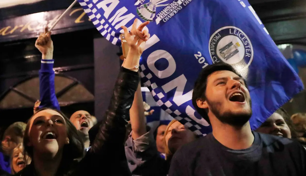 Sejumlah suporter Leicester City berteriak usai timnya berhasil meraih juara Liga Inggris di depan rumah Jamie Vardy, Leicester, (3/5). Leicester Juara setelah saingannya Tottenham bermain imbang 2-2 dengan Chelsea. (Reuters/Eddie Keogh)