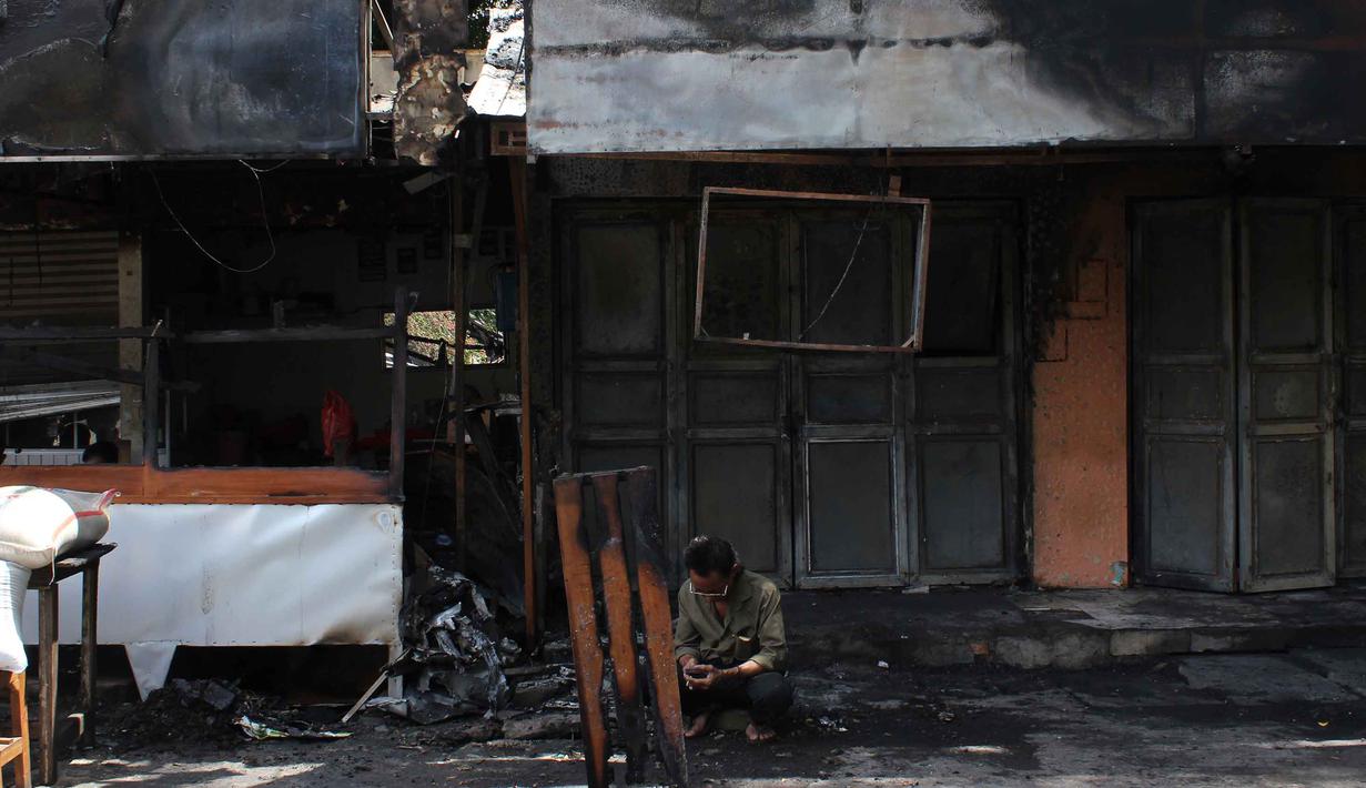 Upaya penagihan tersebut berakhir tragis. Tampak dalam foto, warga beristirahat di depan puing-puing bangunan usai kebakaran yang melanda deretan kios di kawasan Kalibata, Jakarta Selatan, pada Jumat (12/12/2025). (merdeka.com/magang/Rendi Saputra)
