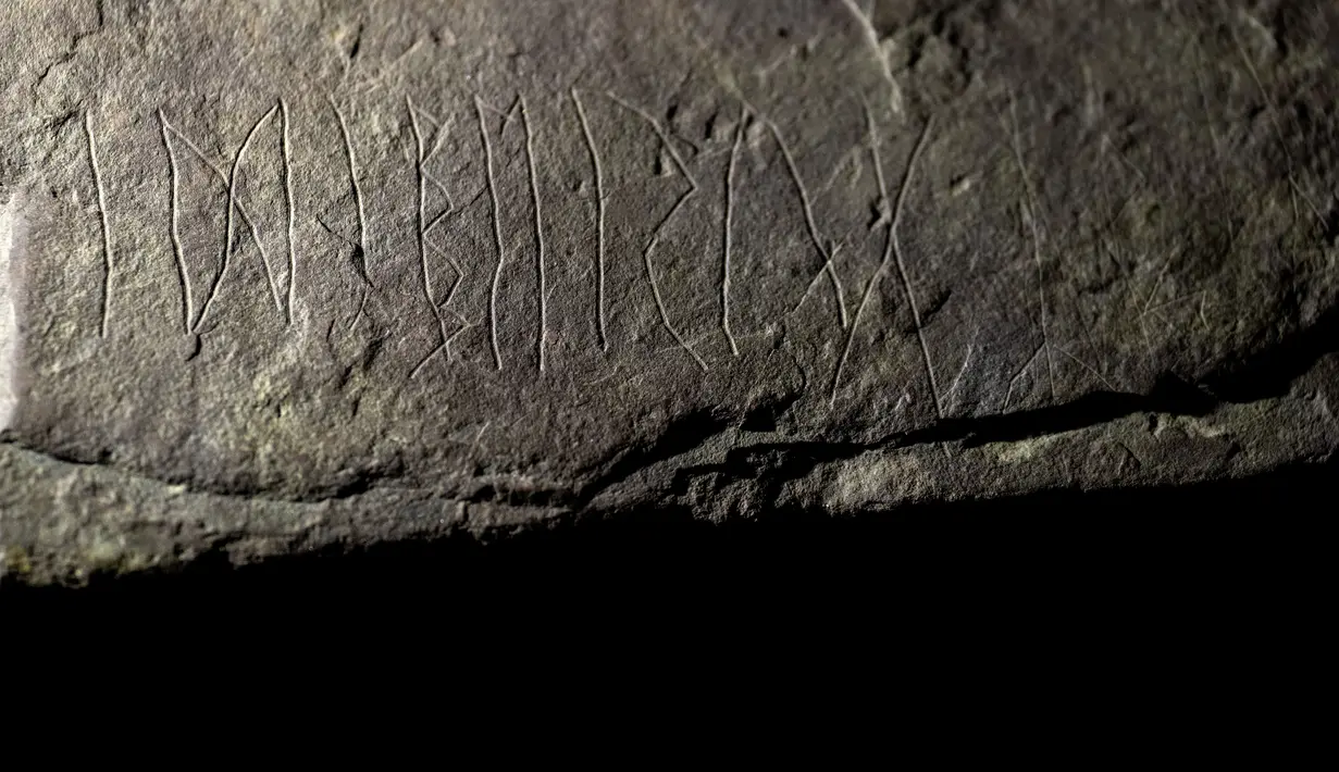 Runestone yang ditemukan di Tyrifjorden, Norwegia, diperlihatkan di Museum Sejarah Budaya di Oslo, pada 12 Januari 2023. Para arkeolog di Norwegia  menyatakan prasasti tersebut berusia hingga 2.000 tahun, berasal dari hari-hari awal sejarah misterius penulisan rahasia. (Javad Parsa/NTB Scanpix via AP)