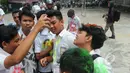 Siswa SMK Kemala Bhayangkari 1 Jakarta, mencoret rambut temannya dengan cat semprot usai mengikuti Ujian Nasional (UN), Kamis (16/4/2015). Aksi tersebut dilakukan sebagai bentuk kegembiraan usai mengikuti UN. (Liputan6.com/Herman Zakharia)