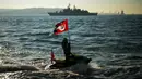 Seorang pria mengangkat bendera Turki dengan potret bapak pendiri Turki Mustafa Kemal Ataturk pada peringatan 84 tahun kematiannya di depan Istana Dolmabahce, Istanbul, Turki, 10 November 2022. Mustafa Kemal Ataturk yang lahir pada 19 Mei 1881 dan meninggal pada 10 November 1938 merupakan pendiri dan presiden pertama Republik Turki. (AP Photo/Francisco Seco)