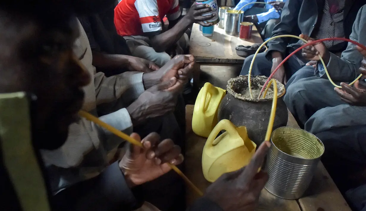 Sejumlah pria meminum air beralkohol dari pot yang disebut Busaa di daerah Nairobi, Kenya, Rabu (8/11). Minuman ini adalah bir tradisional Kenya yang terbuat dari dari tepung sorgum, jagung, atau tepung millet. (AFP Photo/Simon Maina)