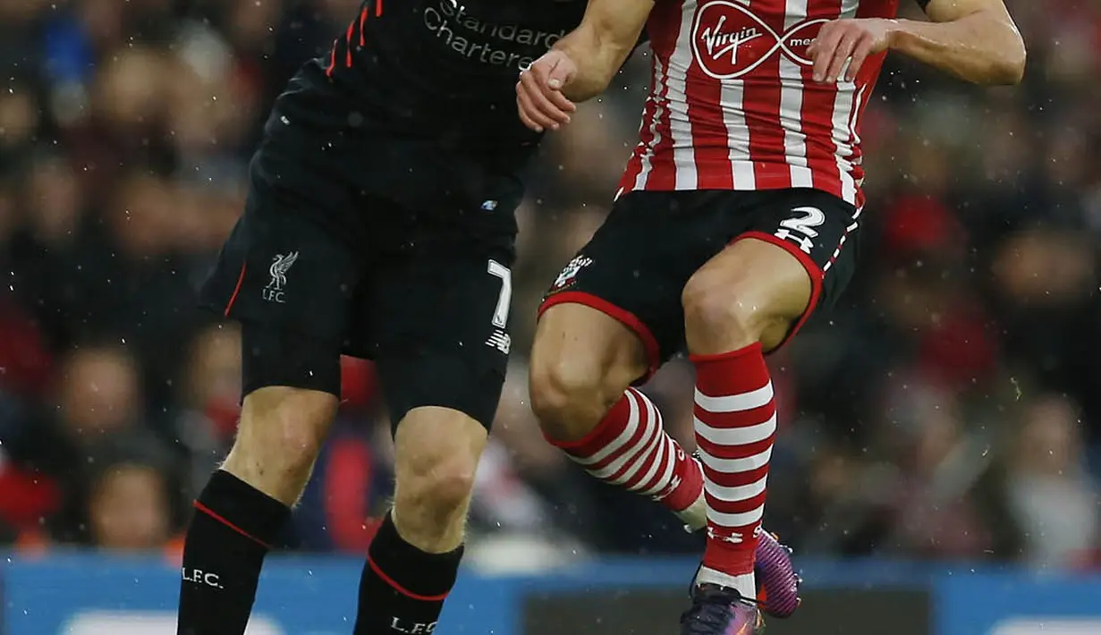 Gelandang Liverpool, James Milner, duel udara dengan bek Southampton, Cedric Soares. Hasil imbang ini membuat posisi Liverpool di puncak klasemen Premier League terancam. (Reuters/Matthew Childs)