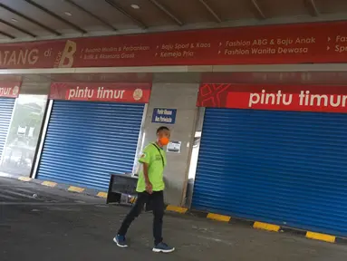 Seorang pria berjalan melewati pertokoan yang tutup di Pasar Tanah Abang, Jakarta, Senin (11/5/2020). Pemerintah Provinsi DKI Jakarta kembali memperpanjang penutupan sementara Pasar Tanah Abang hingga 22 Mei 2020 untuk mencegah penyebaran virus corona COVID-19. (Liputan6.com/Immanuel Antonius)