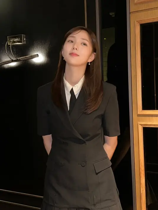 Ia mengenakan dress hitam model blazer, dipadukan kemeja putih dan dasi hitam.  [@soobinms]